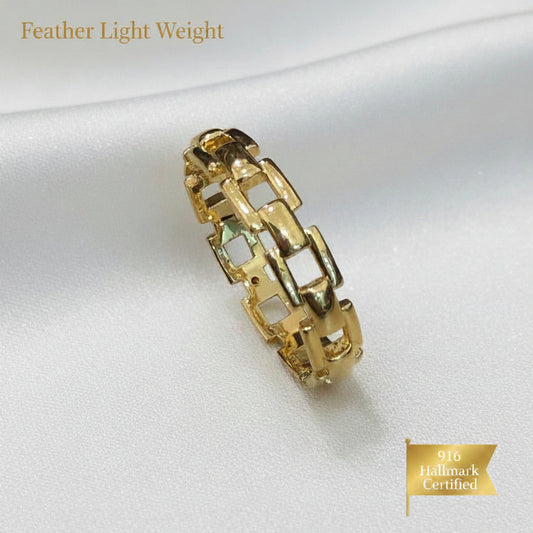Close-up of a 916 gold chain-link ring showing its open geometric links