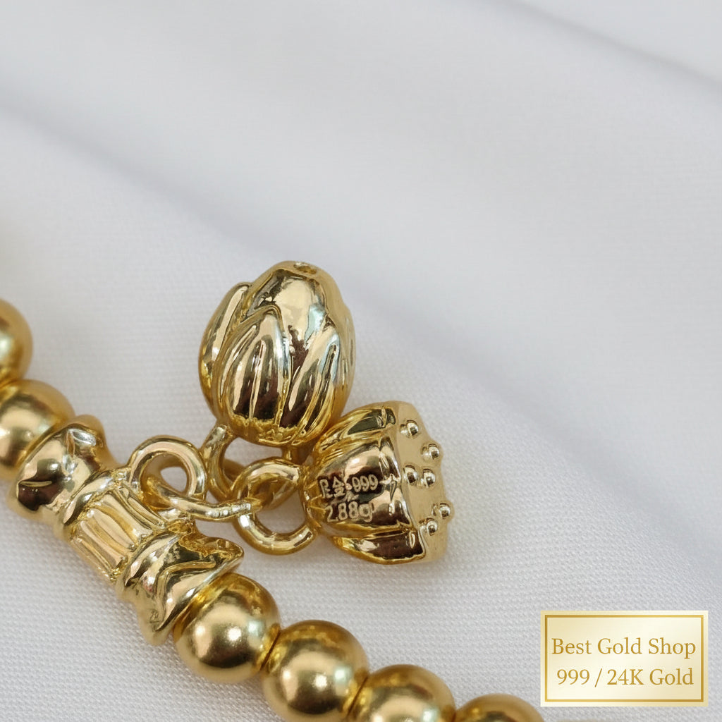 999 gold hallmark and lotus charm detail on bead bracelet