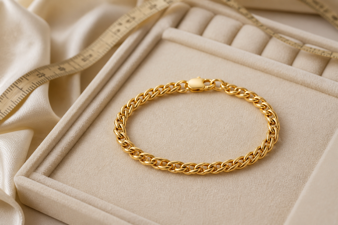 916 gold link bracelet on an ivory jewellery tray beside a measuring tape