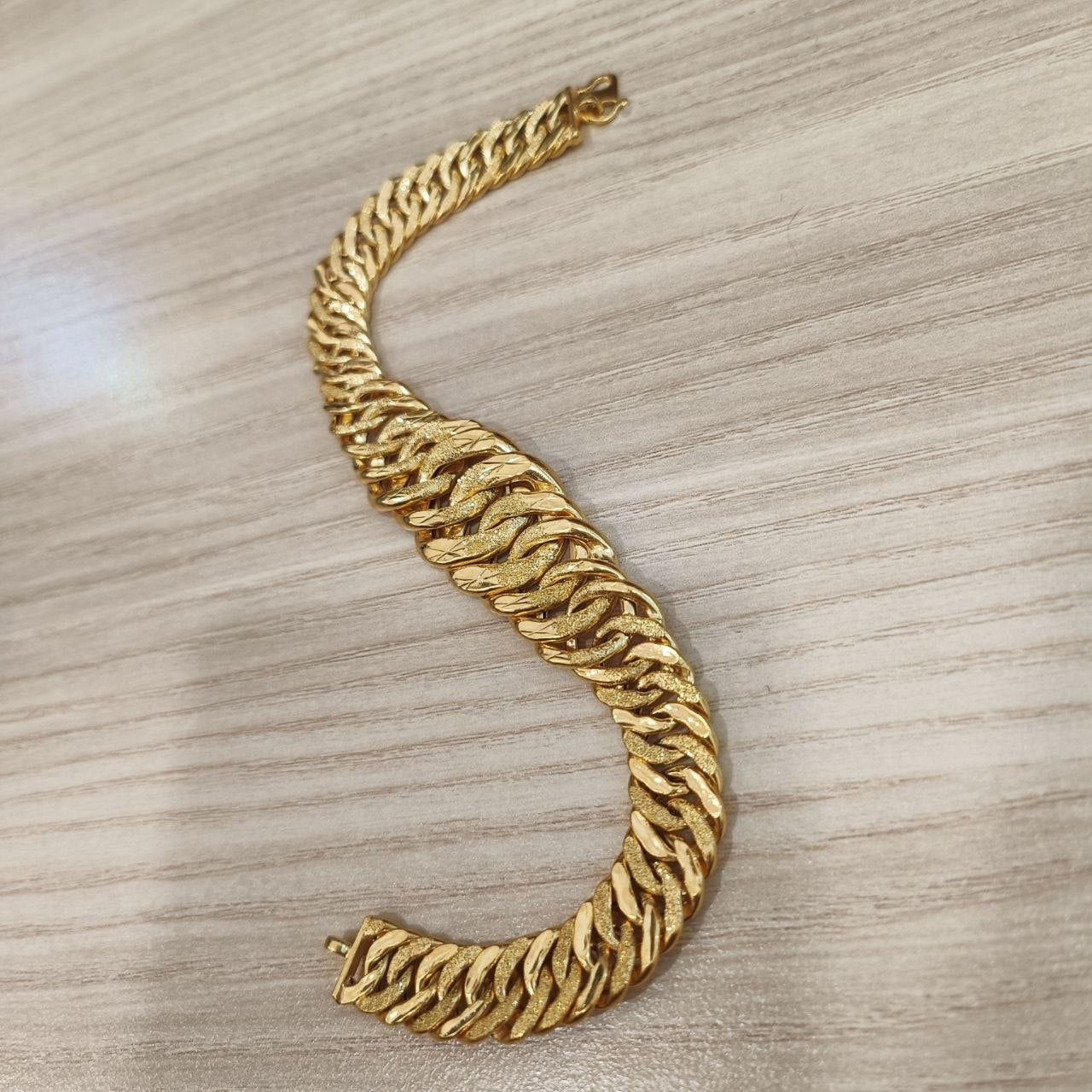 Side view of the wide hollow Lipan link bracelet in yellow gold