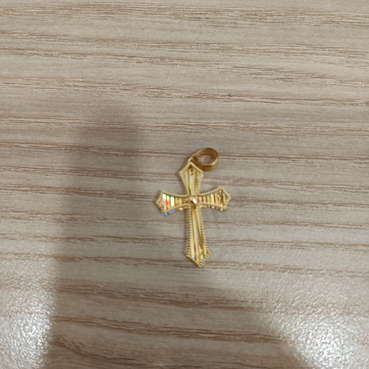 916 gold cross pendant showing rainbow reflective detail